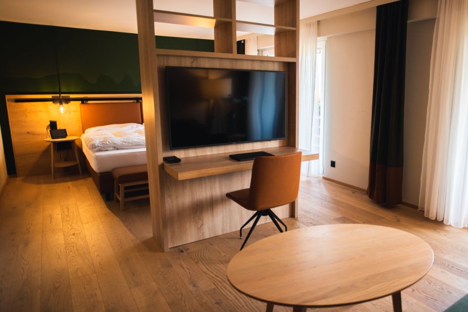 A guest room with a large bed and soft lighting